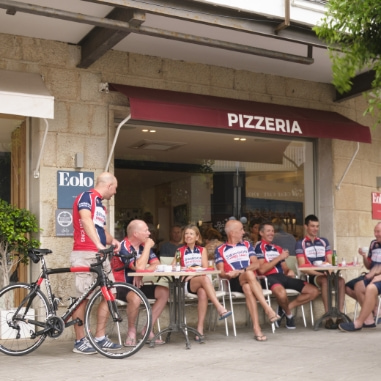 Ciclistas sentados en la terraza del hotel tomando un refrigerio